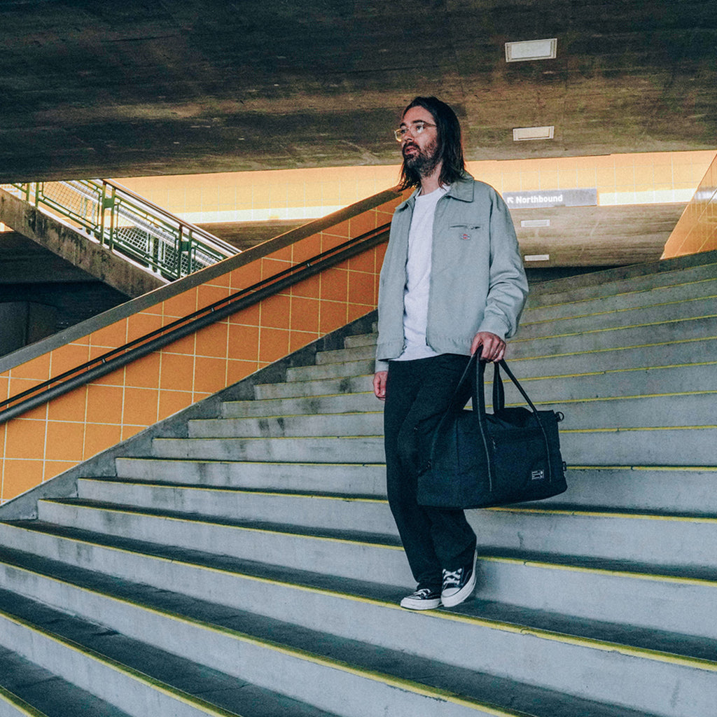 Man holding HEX Evolve Duffel Eco Black, front view