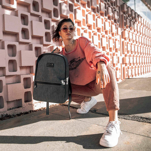 Woman holding HEX Instinct Grey Woven Logic Backpack