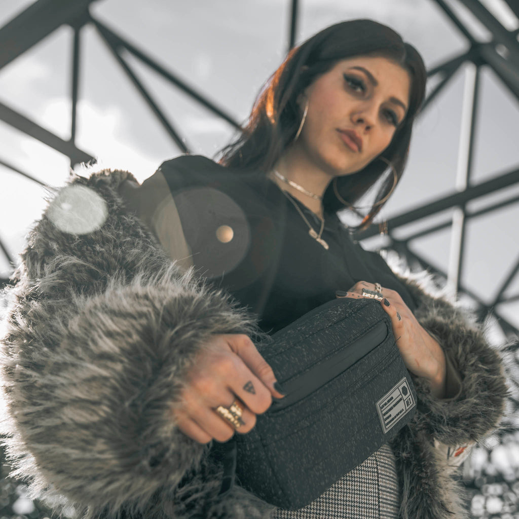 Woman wearing HEX Galaxy Black Reflective Waist Pack across her chest