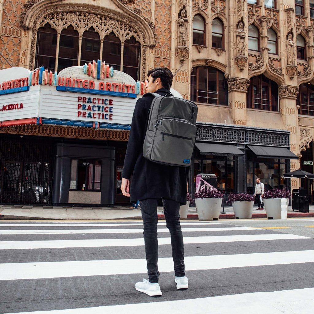 Man standing in the street wearing a HEX x Jim Lee Artist Backpack