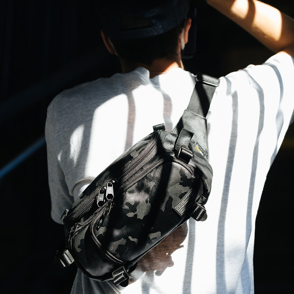 Man wearing the Ranger Blackout Camo Camera Mini Sling